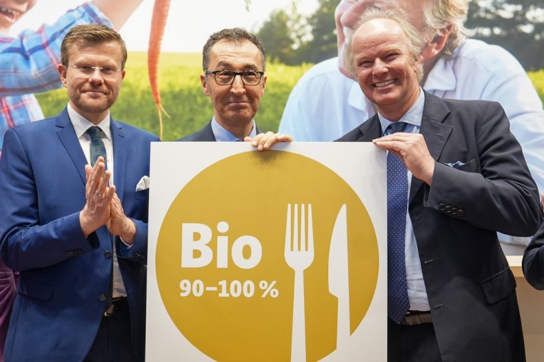 Stefan Hipp, Cem Özdemir und Marcus König halten das Bio-Logo in Gold
