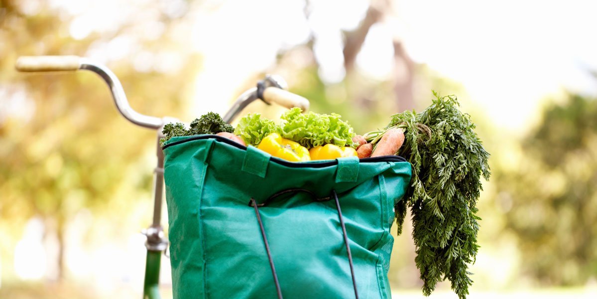 Tüte voller Gemüse auf einem Fahrradgepäckträger.