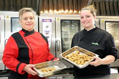 Zwei Frauen mit Schalen voller Falafelbällchen in der Hand. Klick führt zu Großansicht.