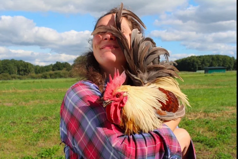 Frau mit Hahn auf dem Arm. Klick öffnet neue Seite auf Oekolandbau.de