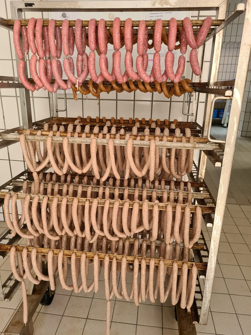Verschiedene Wurstwaren, die auf einem Regal hängen. Klick führt zu Großansicht.