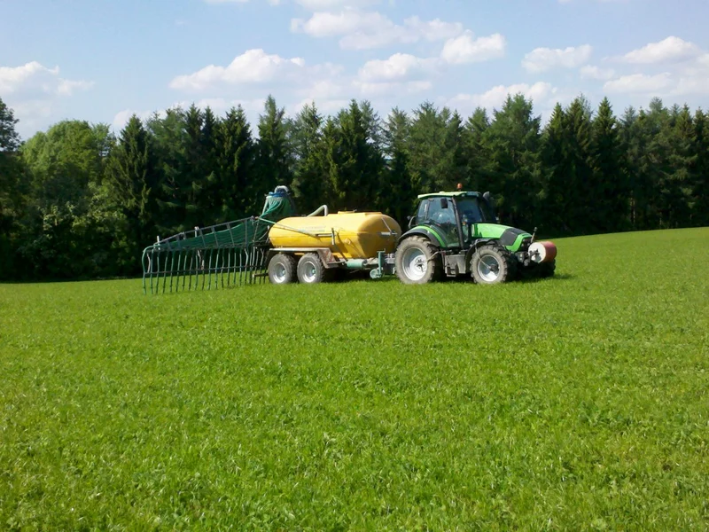 Traktor mit Güllefass auf dem Acker