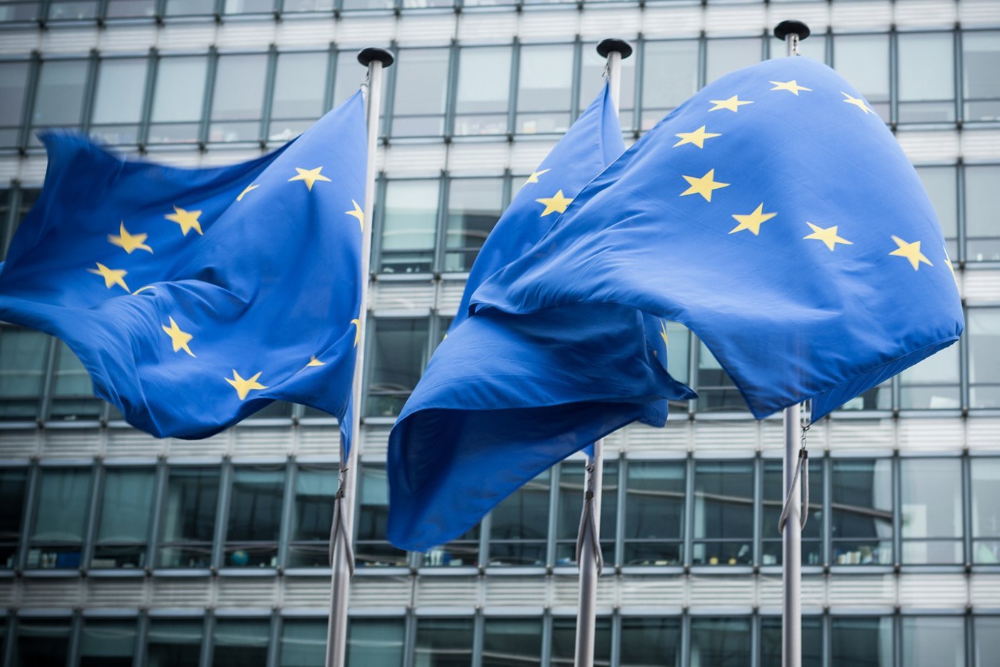 Zwei EU-Flaggen wehen vor einem Gebäude