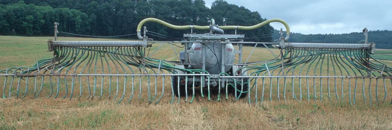 Traktor beim AUsbringen von Gülle auf dem Feld.