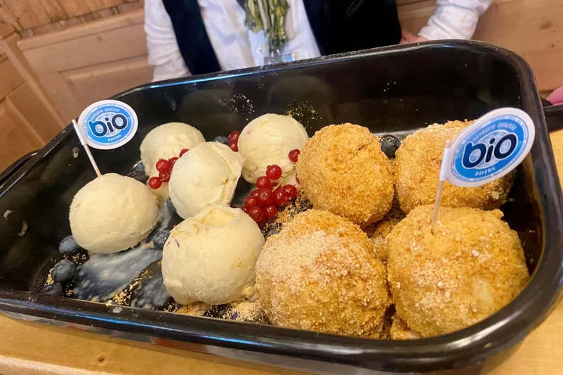Bio-Zwetschgenknödel mit Vanilleeis auf einem Tablett.