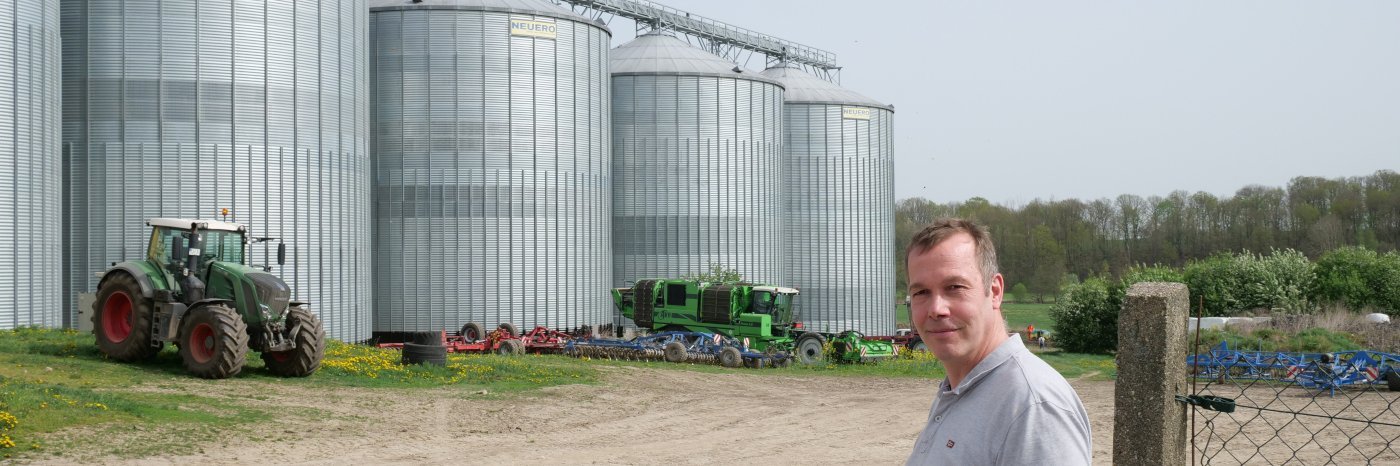 Markus Wiggert steht vor großen Getreidesilos