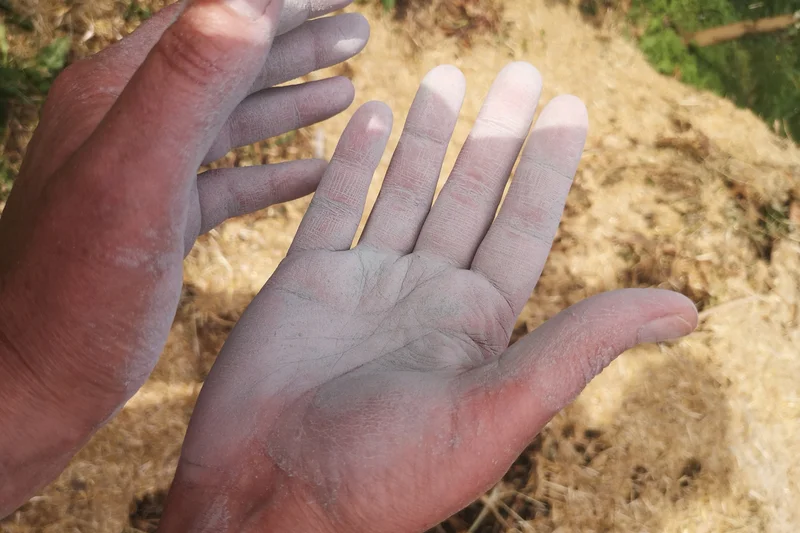 Dünner Film aus Urgesteinsmehl bedeckt eine Hand. Klick führt zur Großansicht im neuen Fenster.