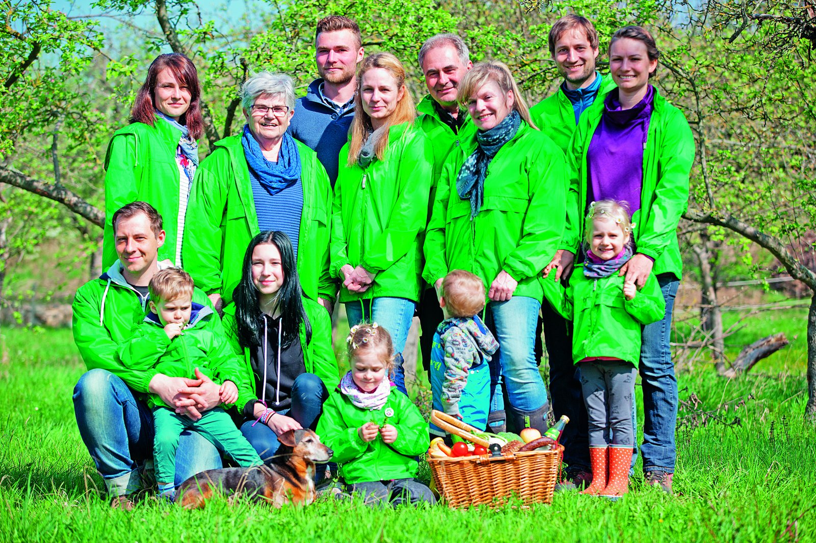 Gruppe Menschen unterschiedlichen Alters mit grünen Jacken