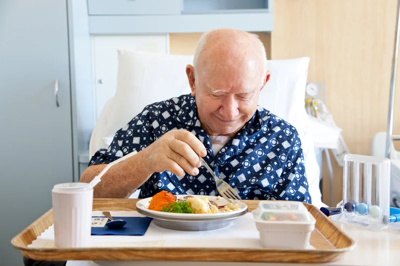 Patient im Krankenhaus beim Essen. Klick führt zu Großansicht im neuen Fenster.