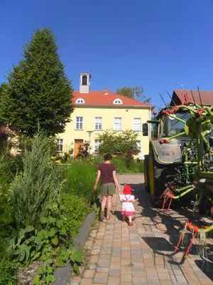 Frau und Kind neben Traktor
