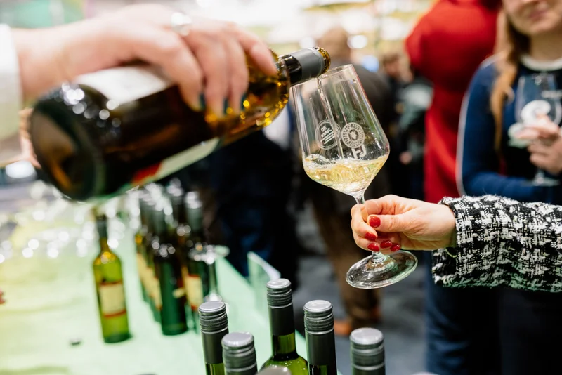 Wein wird aus einer Flasche eingeschenkt.