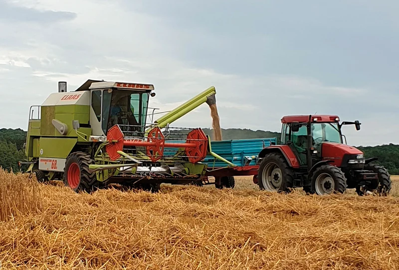 Trecker und große Maschine auf einem Feld