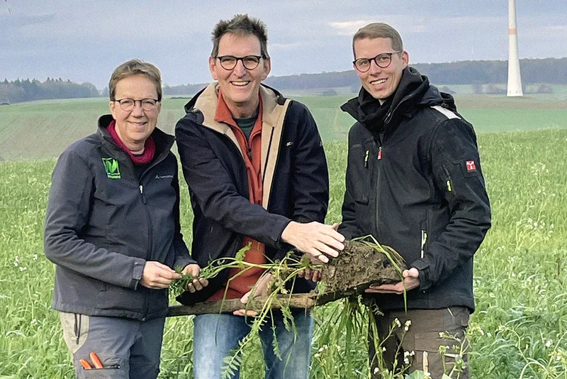 Eine Frau und zwei Männer auf dem Feld