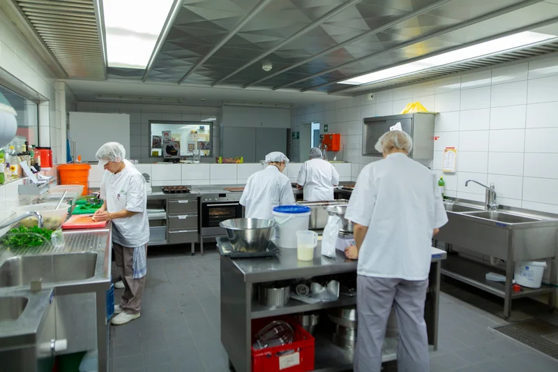 Mitarbeitenden in der Küche der Schulmensa. Klick führt zu Großansicht.