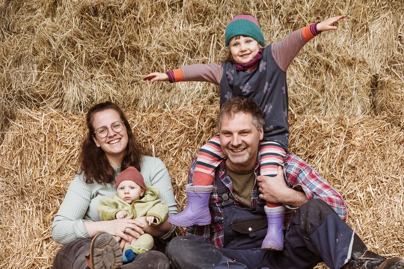 Familie Kreppold mit den zwei kleinen Kindern im Heu