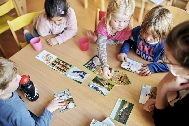 Kita-Kinder spielen ein Kartenspiel