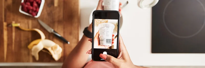 Frau scannt QR-Code auf einer Lebensmittelverpackung, um weitere Produktinformationen zu finden.
