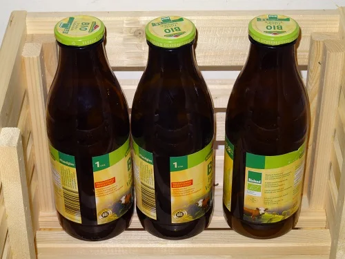 Braune Milchflaschen im Holzkasten. Klick führt zu Großansicht im neuen Fenster.