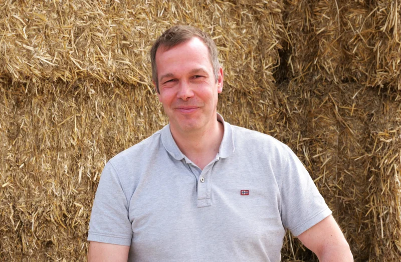 Markus Wiggert im Portrait vor Heuballen
