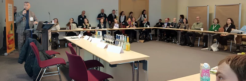 Mehrere Menschen sitzen an einer großen Tischrunde