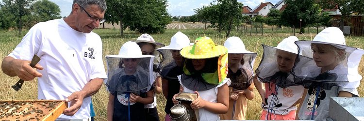 Imker mit Bienen und Kindern. 