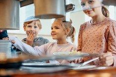 Kinder an einer Essenausgabe in einer Schulkantine. Klick führt zu Großansicht.