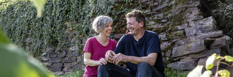 Mann und Frau sitzend im Weinberg