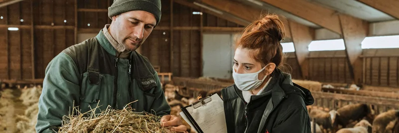 Landwirt und Kontrolleurin im Stall