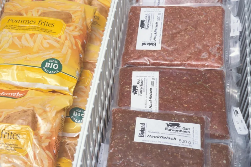 Pommes und Fleisch verpackt in einer Kühltruhe. Klick führt zu Großansicht.
