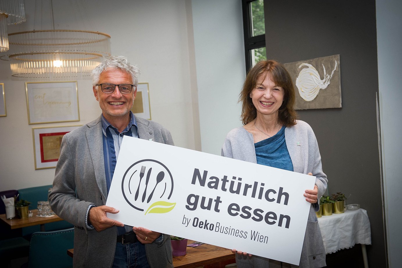 Mann und Frau mit "Natürlich gut essen"-Plakette. Foto: OekoBusiness, Wien