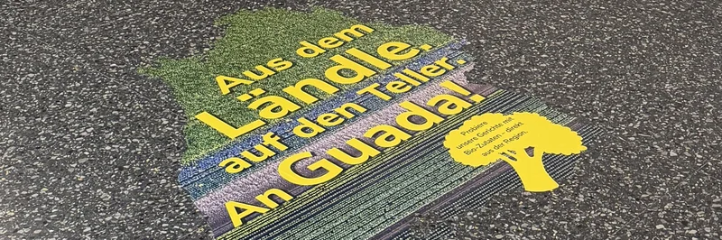 Bodenaufkleber in der Mensa mit dem Spruch: "Aus dem Ländle auf den Teller. An Guada".