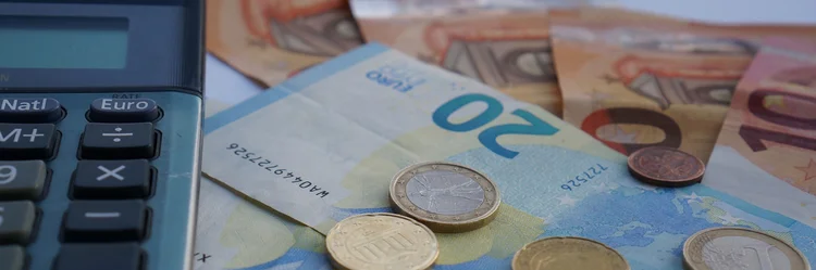 Taschenrechner mit Euro-Scheinen und Münzen.