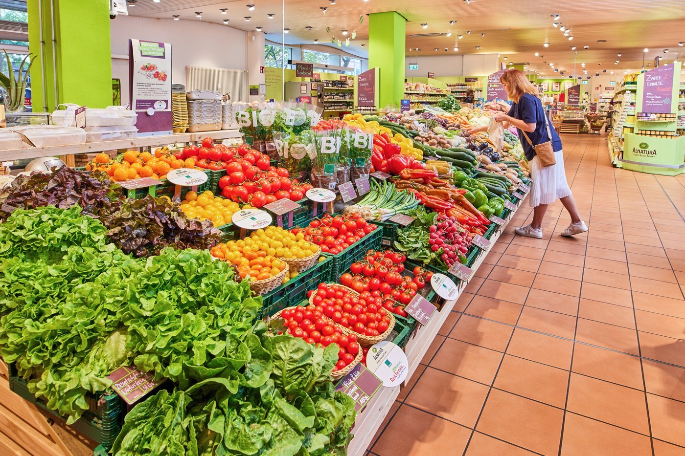 Frau kauft frisches Gemüse im Bio-Supermarkt ein.