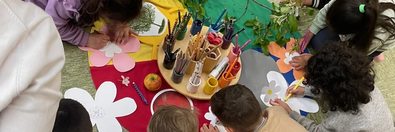 Kinder sitzen auf dem Boden im Kreis und arbeiten mit dem "Bauernhof im Koffer".