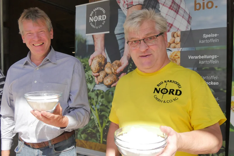 Zwei Herren mit einer Schale Kartoffelstärke.