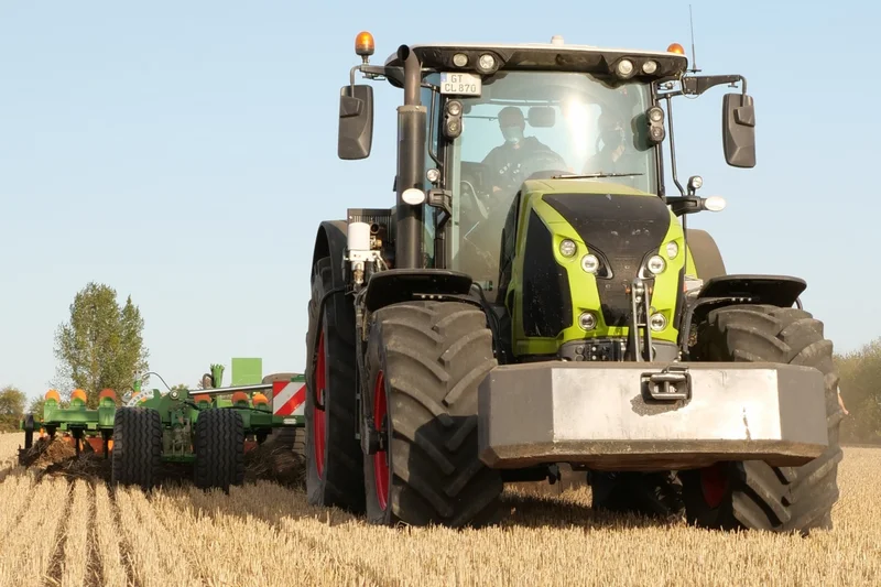 Traktor bei der Bodenbearbeitung mit Ballastierung. Klick führt zu Großansicht.