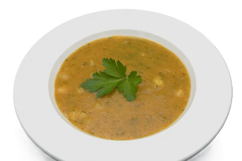 Türkische Linsensuppe mit frischer Petersilie auf einem hellen Keramikteller. Foto: DIVERSA