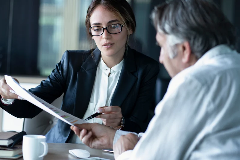 Junge Frau und älterer Mann verhandeln. Foto: sebra / Adobe Stock