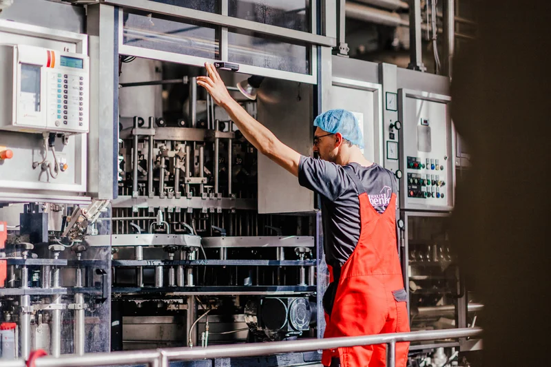 Ein Mitarbeiter des Unternehmens Rabenhorst beobachtet die Maschine beim Produktionsprozess. Klick führt zu Großansicht in neuem Fenster.