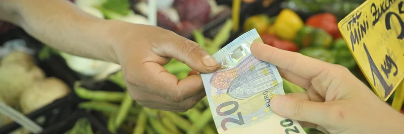 20-Euro-Schein-Übergabe beim Einkauf auf Wochenmarkt. Klick führt zu Großansicht in neuem Fenster.