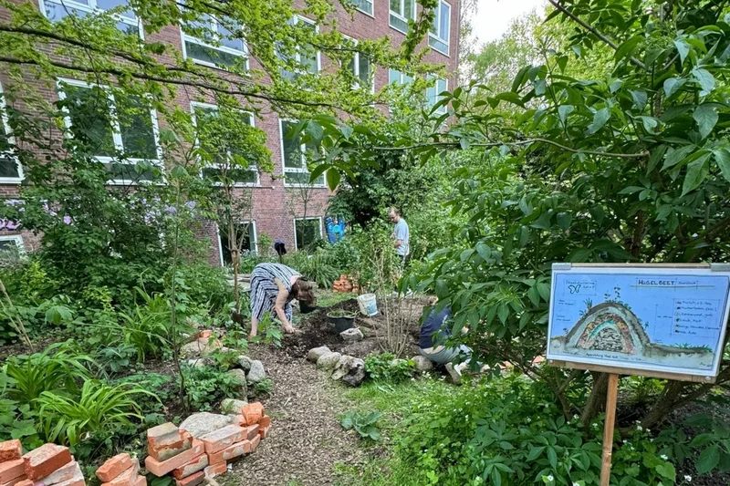 Menschen in einem Permakulturgarten. Klick führt zu Großansicht.
