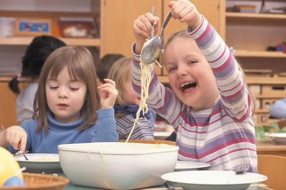 Kinder essen Spaghetti.