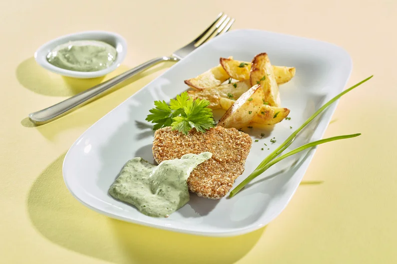 Seitanschnitzel mit Remouladensauce auf Teller angerichtet.