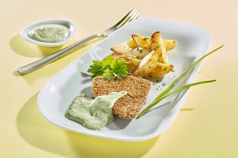 Seitanschnitzel mit Remouladensauce auf Teller angerichtet.