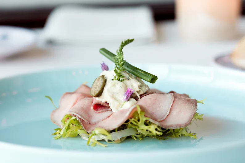Vitello tonnato vom Hinterwälder Rind auf Friséesalat. Klick öffnet neues Fenster zum Rezept.