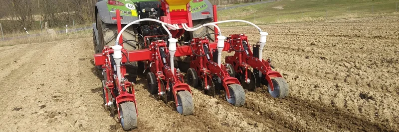 Traktor fährt über einen Acker.