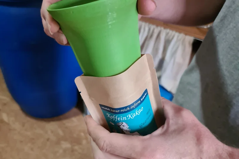 Hände wie sie in eine Tüte etwas abfüllen. Klick führt zu Großansicht.