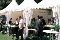 Menschen einem Stand auf einer Ausstellung. Klilck führt zu Großansicht.