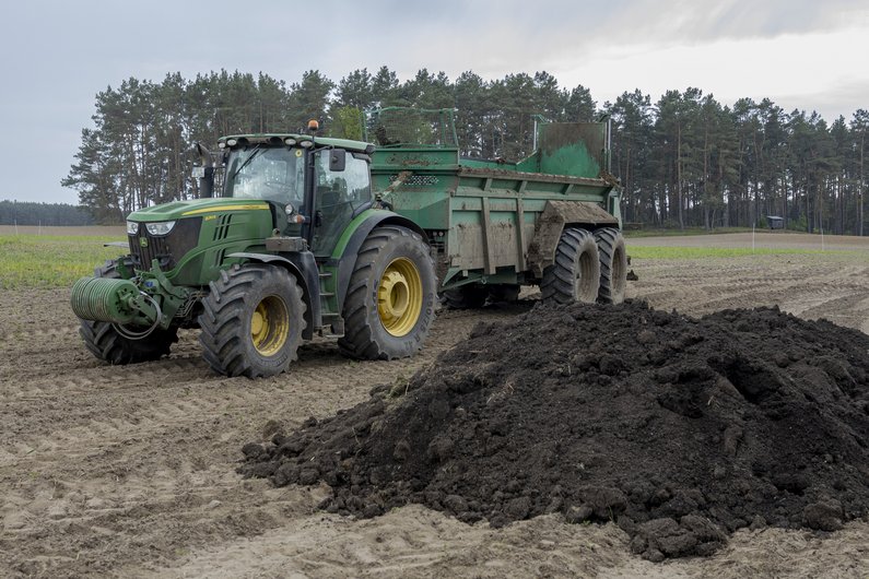 Humusdünger wird auf einem Feld verteilt