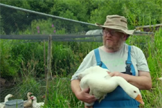 Mann mit Gans im Arm.